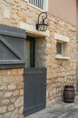 Tahta kapılı ve kırsal varili olan taş ev cephesi. Yüksek kalite fotoğraf