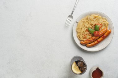 Minimalist masa düzeninde domatesli lezzetli spagetti ve sosis. Yüksek kalite fotoğraf