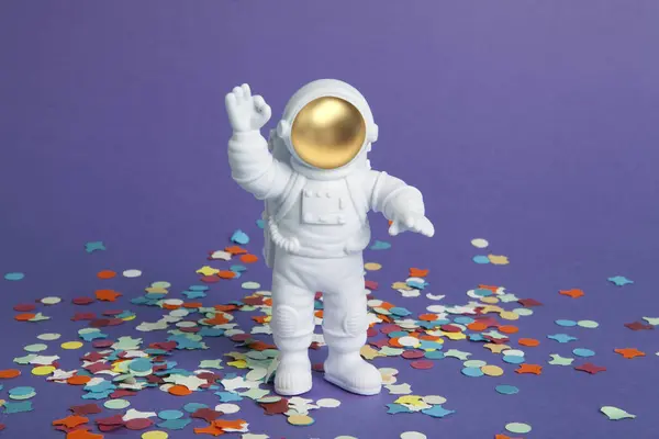 Astronaut Figurine Spacesuit Exploring Plain Purple Background Confetti Carpet Minimal — Stock Photo, Image
