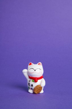 bir Maneki-neko plastik kedi, şans ve zenginlik sembolize, bir pop ve renkli arka plan üzerinde