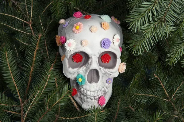 異なる色の複数のプラスチックの花で覆われた頭蓋骨 墓としての枝の比喩 人間の生命の脆弱性を表すものとしての虚栄心 — ストック写真