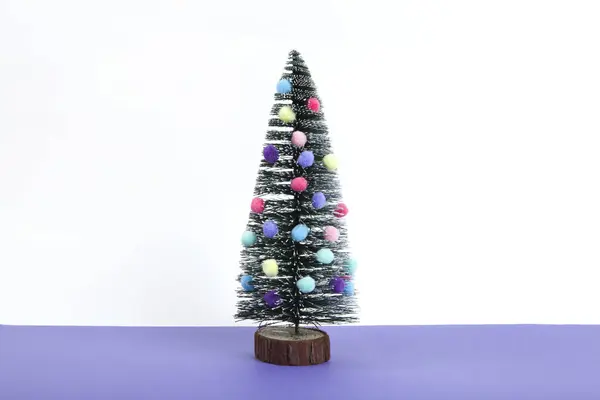 小型圣诞树 装饰有迷你的花环和石榴 作为灌木 紫罗兰和白色背景 最低限度的静物摄影 — 图库照片