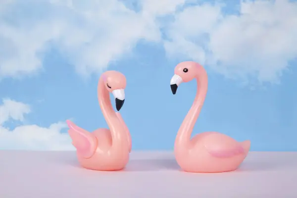 Para Różowych Plastikowych Łabędzi Tle Błękitnego Letniego Nieba Białymi Chmurami — Zdjęcie stockowe