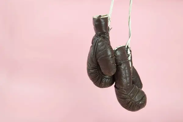 古いボクシングの手袋が キャンディピンクの背景の前に掛けられています ミニマルカラーとキレイカラーはまだライフフォト ストック写真
