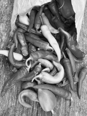 Tema üzerine uzun kırmızı acı biber, akut sebze. Fotoğraf, kırsal kesimin arka planında kıvrımlı kırmızı acı biberden oluşur. Mutfakta pişirme menüsü için baharat. Kırmızı acı biber.