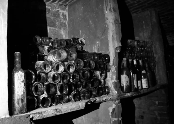 ワインの非常に古代のボトルはレトロダークセラーにあります 高石のスタンド上のユニークなセラーでワインの希少なヴィンテージボトル レストラン ストリートカフェ バーのためのアルコールセラーの多くの古いボトル — ストック写真