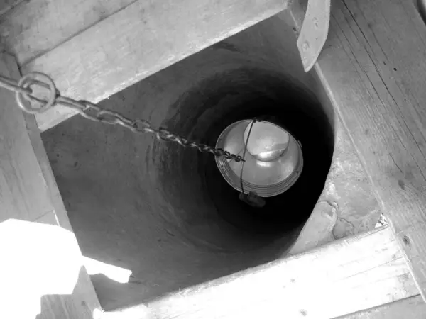 用铁桶固定在清洁饮用水的长链上的老井 由圆形的旧井顶 大桶中的清水 老井中铝桶中的泉水组成的摄影 — 图库照片