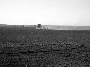 Kara toprakta traktörle sürülmüş tarla açık arazide traktör tarlada traktör, toprakta yetişen lezzetli sebzeler temiz karanlık gökyüzünün altında organik tarlalar traktör için doğal topraktır.