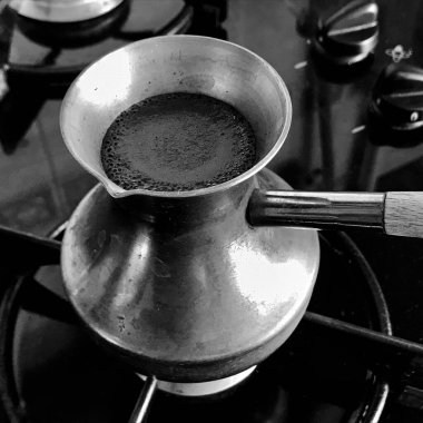 Barista bakır Türk 'ten sıcak bir içecek hazırlıyor, Cezve' deki küçük ateşte kahve için su kaynatıyor, organik bakırdan yapılmış kahve Türk kahvesi, Crisve 'de gerçek gurme kahve için bakır Türk kahvesi yapıyor.