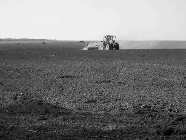 Kara toprakta traktörle sürülmüş tarla açık arazide traktör tarlada traktör, toprakta yetişen lezzetli sebzeler temiz karanlık gökyüzünün altında organik tarlalar traktör için doğal topraktır.