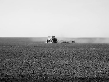 Kara toprakta traktörle sürülmüş tarla açık arazide traktör tarlada traktör, toprakta yetişen lezzetli sebzeler temiz karanlık gökyüzünün altında organik tarlalar traktör için doğal topraktır.