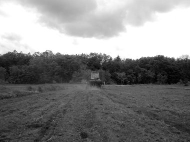 Kara toprakta traktörle sürülmüş tarla açık arazide traktör tarlada traktör, toprakta yetişen lezzetli sebzeler temiz karanlık gökyüzünün altında organik tarlalar traktör için doğal topraktır.
