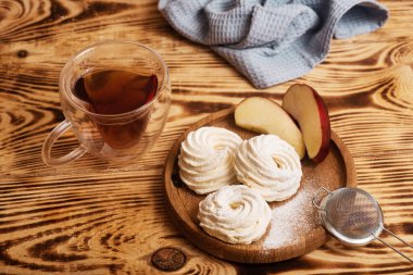 El yapımı marşmelov. Doğal tatlılık. Elmalı Zephir ve tahta yüzeyde bir fincan çay. Nefis tatlı. Fındık