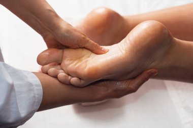 Masseur doing foot massage with oil in spa salon. Spa procedures. relaxing, wellness foot massage. Body care concept. Close-up view. Female foot close-up