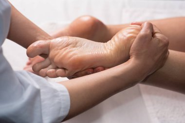Masseur doing foot massage with oil in spa salon. Spa procedures. relaxing, wellness foot massage. Body care concept. Close-up view. Female foot close-up