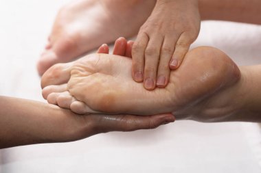 Masör kaplıca salonunda yağ ile ayak masajı yapıyor. Spa prosedürleri. Rahatlatıcı, sağlıklı ayak masajı. Vücut bakımı konsepti. Yakın çekim görüntüsü. Kadın ayağı yakın plan.