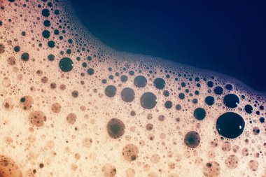 Su yüzeyinde köpüren kalın sabun köpükleri. Güzel parlak, modaya uygun renkler, maviden kırmızıya değişim. Makro. Sabun köpüğü dokusu, köpük.