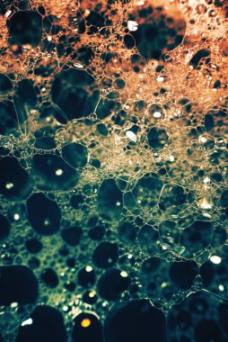 Su yüzeyinde köpüren kalın sabun köpükleri. Güzel parlak, modaya uygun renkler, maviden kırmızıya değişim. Makro. Sabun köpüğü dokusu, köpük.