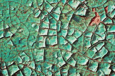 Yüzeydeki çatlak boyanın makro dokusu. Moda kırmızısı ve turkuaz renklerinde klasik arka plan. detaylı doku detaylı doku. Eski boyalı yüzeyde geniş hacimli çatlaklar