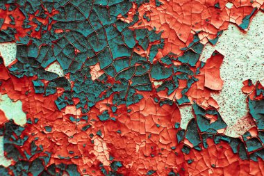 Yüzeydeki çatlak boyanın makro dokusu. Moda kırmızısı ve turkuaz renklerinde klasik arka plan. detaylı doku detaylı doku. Eski boyalı yüzeyde geniş hacimli çatlaklar