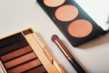 Dekoratif kozmetik ürünler, göz falı paletleri ve beyaz arka planda yakın plan kozmetik fırça, üst görüş. Makro. Makyaj sanatçısı iş akışı. Güzellik konsepti