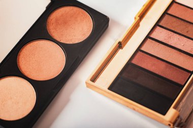 Dekoratif kozmetik ürünler, göz falı paletleri ve beyaz arka planda yakın plan kozmetik fırça, üst görüş. Makro. Makyaj sanatçısı iş akışı. Güzellik konsepti