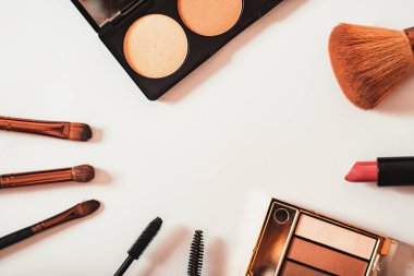Dekoratif kozmetik ürünleri, fırçalar, göz farı, ruj, toz ve göz leşleri beyaz arka planda daire şeklinde dizilir. Çerçeve. Makyaj Sanatçısı İçeriği, Metin Boşluğu