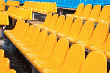 Stadyumdaki boş koltuklar. Mavi ve sarı sandalyeler, basit soyut bir spor şovunda kimse bulunmaz. Sandalyeler yakın, yan görünüm