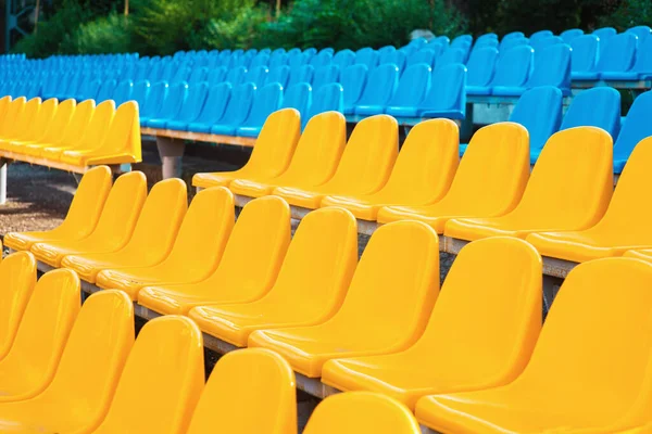 stock image Empty rows of seats in the stadium. Blue and yellow chairs, nobody present at a sport show simple abstract concept. Chair rows up close, side view