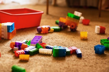 Çocukların plastik yapı taşları odanın zeminine saçılmış. Oda düzensiz bir halde. Rtx, mesaj yeri, mutlu çocukluk. Rahat atmosferi olan rahat bir ev. Çocuk gelişimi