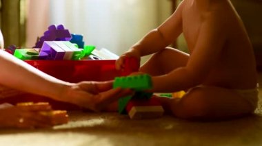 Sevimli çocuk annesiyle plastik inşaatçıdan kule inşa ediyor. Annesi umursuyor, hemşireler ve bebeğine öğretiyor. Mutlu bir çocukluk dönemi. Rahat atmosferi olan rahat bir ev. Çocuk gelişimi, ince motor