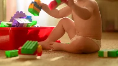 Sevimli çocuk annesiyle plastik inşaatçıdan kule inşa ediyor. Annesi umursuyor, hemşireler ve bebeğine öğretiyor. Mutlu bir çocukluk dönemi. Rahat atmosferi olan rahat bir ev. Çocuk gelişimi