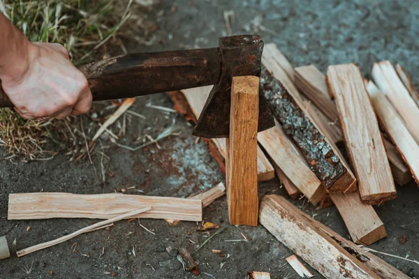 stock image Chopping wood for the fire with an axe. A man's hand with an axe chopping wood, close-up. Preparing for the barbecue. Making firewood. Lumberjack