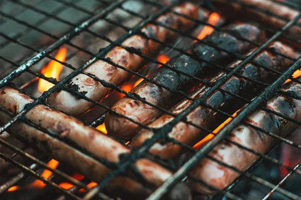 烧烤烤架上的牛奶香肠在火上烘烤 香肠在火的火焰中 我们的门 美味的烤香肠 — 图库照片