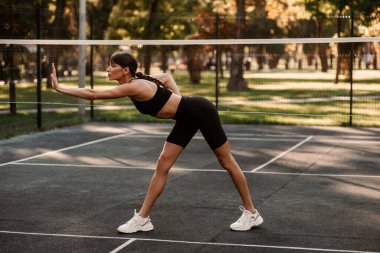 Atletik vücutlu genç bir kız spor sahasında spor yapıyor. Spor hocası. İnce vücut. Sağlıklı bir yaşam tarzı. Sporcu kadın antrenman yapıyor. Yüksek kalite fotoğraf