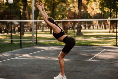 Atletik vücutlu genç bir kız spor sahasında spor yapıyor. Spor hocası. İnce vücut. Sağlıklı bir yaşam tarzı. Sporcu kadın antrenman yapıyor. Yüksek kalite fotoğraf