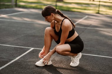 Atletik vücutlu genç bir kız spor sahasında spor yapıyor. Spor hocası. İnce vücut. Sağlıklı bir yaşam tarzı. Sporcu kadın antrenman yapıyor. Yüksek kalite fotoğraf