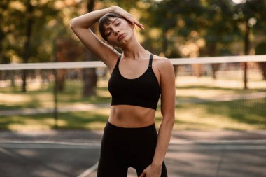 Genç bir bayan antrenör fitness sıkıştırma egzersizi yapıyor. Kız dışarıda antrenman yapıyor. Sağlıklı bir yaşam tarzı. Yüksek kalite fotoğraf