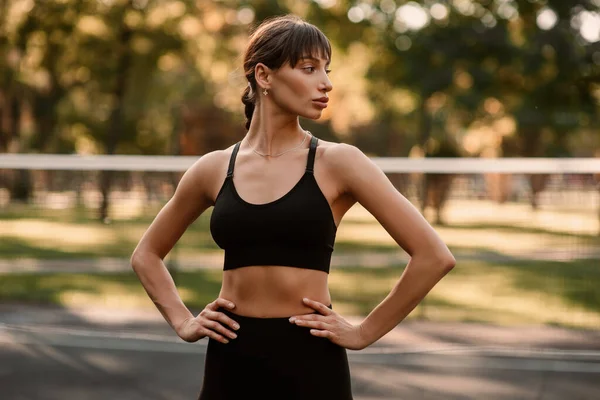 Genç bir bayan antrenör fitness sıkıştırma egzersizi yapıyor. Kız dışarıda antrenman yapıyor. Sağlıklı bir yaşam tarzı. Yüksek kalite fotoğraf