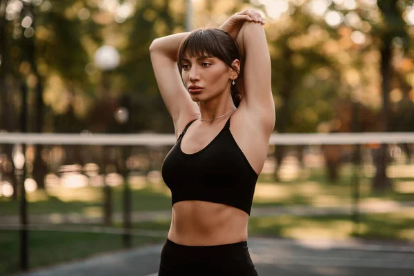 Genç bir bayan antrenör fitness sıkıştırma egzersizi yapıyor. Kız dışarıda antrenman yapıyor. Sağlıklı bir yaşam tarzı. Yüksek kalite fotoğraf