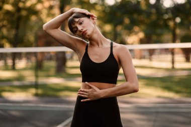 Genç bir bayan antrenör fitness sıkıştırma egzersizi yapıyor. Kız dışarıda antrenman yapıyor. Sağlıklı bir yaşam tarzı. Yüksek kalite fotoğraf