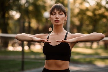 Genç bir bayan antrenör fitness sıkıştırma egzersizi yapıyor. Kız dışarıda antrenman yapıyor. Sağlıklı bir yaşam tarzı. Yüksek kalite fotoğraf