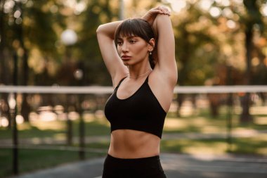 Genç bir bayan antrenör fitness sıkıştırma egzersizi yapıyor. Kız dışarıda antrenman yapıyor. Sağlıklı bir yaşam tarzı. Yüksek kalite fotoğraf