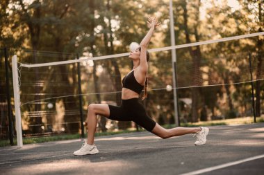 Genç bir bayan antrenör fitness sıkıştırma egzersizi yapıyor. Kız dışarıda antrenman yapıyor. Sağlıklı bir yaşam tarzı. Yüksek kalite fotoğraf