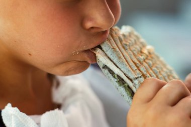 Avrupalı görünümlü genç bir çocuk sandviçi ısırıyor. Ağıza yakın çekim. Fast food yiyorum. Atıştırmalık Yemek yeme süreci. Yüksek kalite fotoğraf