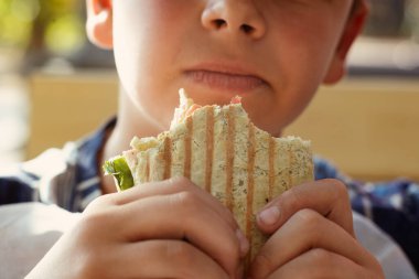 Genç adam fast food yiyor. Yemek yeme süreci. Bir şeyler atıştır. Sokak yemeği reklamları. Yüksek kalite fotoğraf
