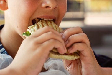 Genç adam fast food yiyor. Yemek yeme süreci. Bir şeyler atıştır. Sokak yemeği reklamları. Yüksek kalite fotoğraf