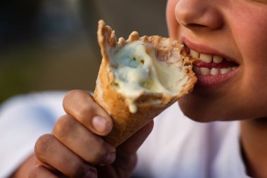 Ergen çocuk abur cubur yiyor. Atıştırmalık, tatlı, sokak yemeği. Orta boy yemek. Dişleri, dili ve tükürük makrosu olan bir ağız. Yemek yeme süreci. Yüksek kalite fotoğraf