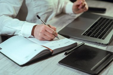 Bilgisayarın başında çalışan bir kız. Elinde telefon ve not defteri var. Çevrimiçi öğrenme, finans, iş, uzaktan çalışma. Çalışıyorum. Yüksek kalite fotoğraf