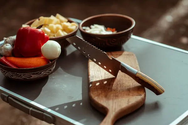 木の外でナイフと木製の板で調理するタブレットのためのスライスされた指 家の外で料理をする 高品質の写真 ロイヤリティフリーのストック画像